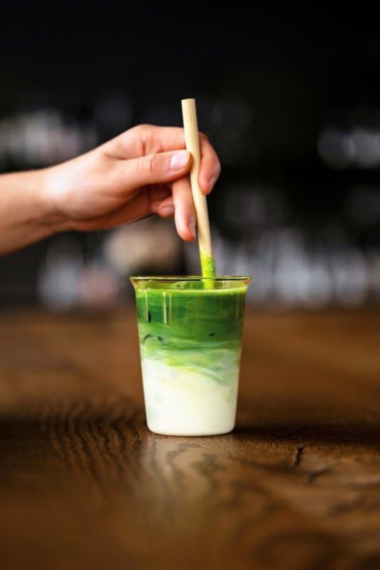 A fresh matcha latte being poured
